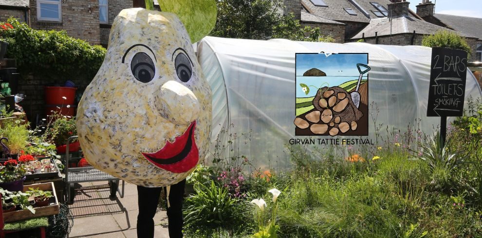 An image of someone dressed as a potato in a garden posing for the camera.