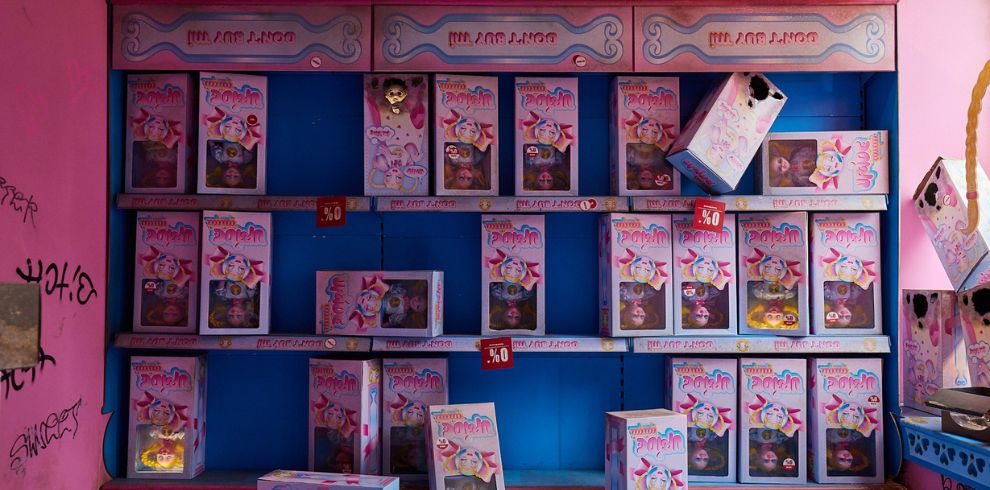 Image of inside Jupiter+ exhibition with dolls in boxes situated on shelves.