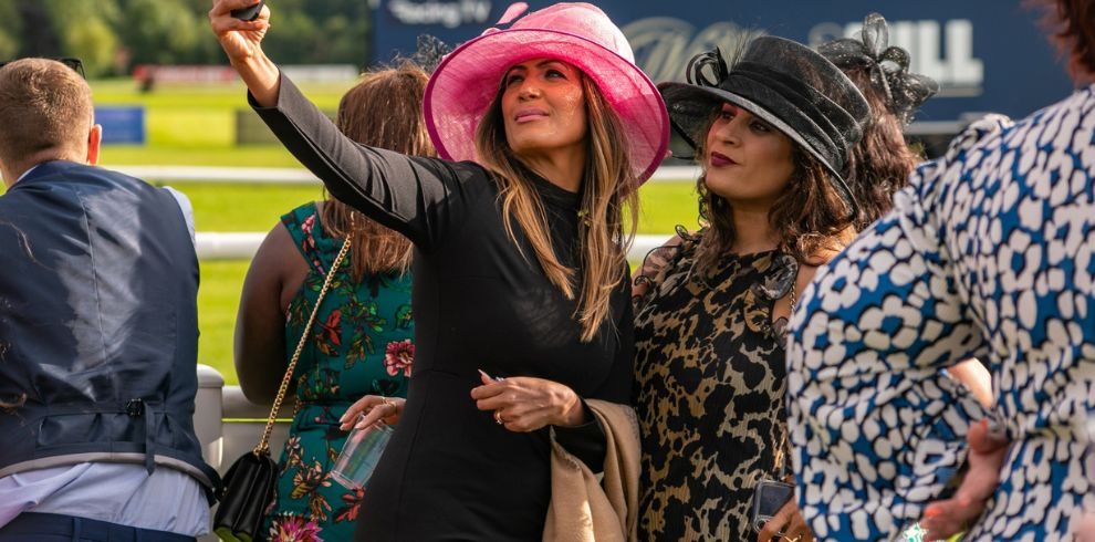 An image of two women at races taking a selfie.