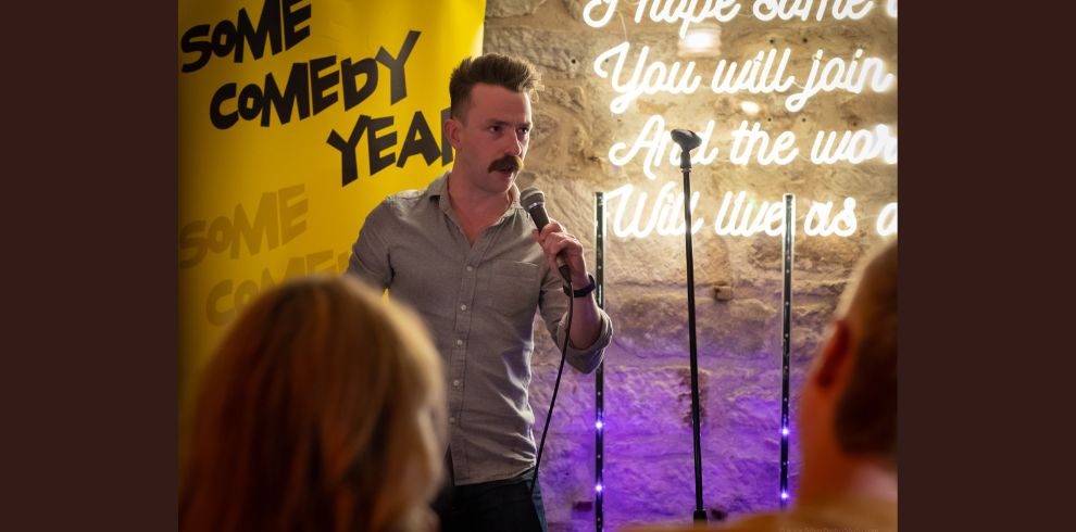 An Image of a man speaking in front of an audience.